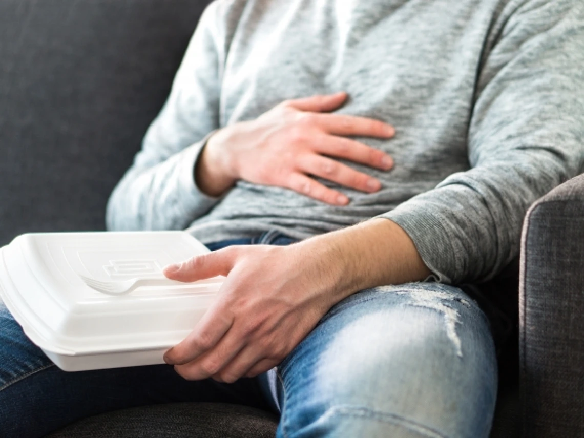 Man holding hand over stomach feeling full